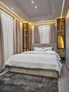 a bedroom with a large bed with white sheets at Jeffreys Apartments in Lagos