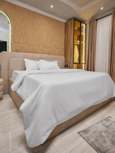a bedroom with a large bed with white sheets at Jeffreys Apartments in Lagos