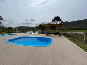 a large blue swimming pool on a patio at Morada do Campo in Biguaçu