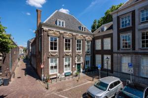 un vecchio edificio con una macchina parcheggiata di fronte di B&B Cleyn Cruysenborgh 1531 a Dordrecht