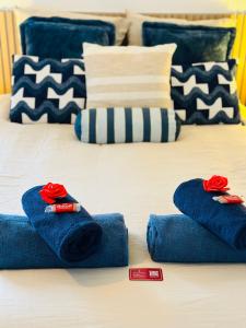 a bed with blue towels and red roses on it at L'Ecume - Le Rheu in Le Rheu