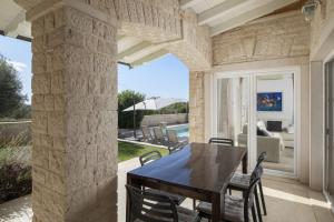 a dining room with a table and chairs on a patio at Villa Mason with Heated Pool and mini Wellness in Rovinjsko Selo