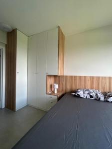 a bedroom with a large bed and a cabinet at Studio em Belém perto do Shopping Bosque e Parque da Cidade in Belém