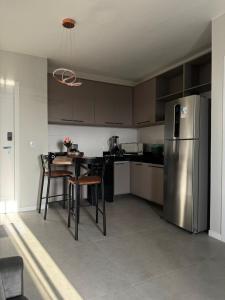 eine Küche mit Tisch und Edelstahlkühlschrank in der Unterkunft Studio em Belém perto do Shopping Bosque e Parque da Cidade in Belém