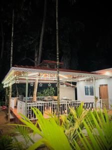 a house with a white porch with lights on it at Seaside Beach Resort in Diveagar +16 photos