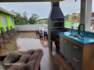 a kitchen with a fireplace and a couch in a living room at Pousada do Sossego Mar e verde 3 in Itanhaém