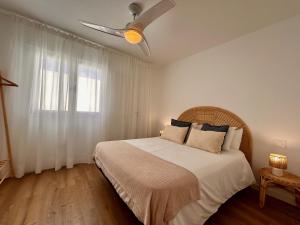 Un dormitorio con una cama con ventilador de techo. en La Molina 2, en Cotillo