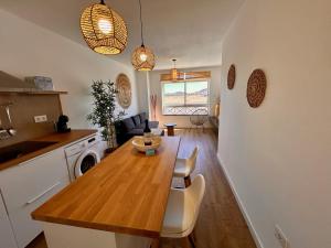 cocina y sala de estar con mesa de madera en la cocina en La Molina 2, en Cotillo 5 fotos más