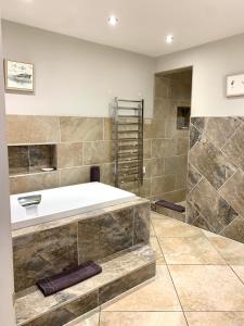 Un baño grande con bañera y ducha. en The Old Bakery - Luxury Three Bed House with Roof Terrace, en Whitby