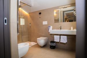 a bathroom with a sink and a toilet and a mirror at Hotel Perla del Gargano in San Giovanni Rotondo +21 photos