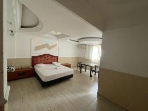 une chambre avec un lit et une table dedans dans l'établissement Hotel Vitória de Santos, à Santos 17 autres photos