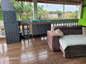 イタニャエンにあるPousada do Sossego Mar e verde 3のソファと洗面台のあるリビングルーム