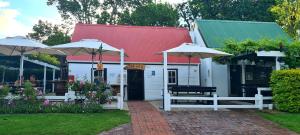 a building with two umbrellas in a yard at Belvidere Garden Apartment in Knysna