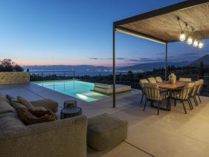 a patio with a table and chairs and a pool at Terra Maina Villa in Avía