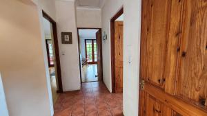 a hallway with wooden doors and a tile floor at Belvidere Garden Apartment in Knysna