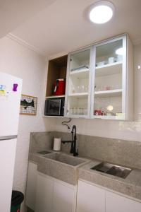a kitchen with a sink and a refrigerator at Apartamento Confortável e Acolhedor in Diamantina +33 photos
