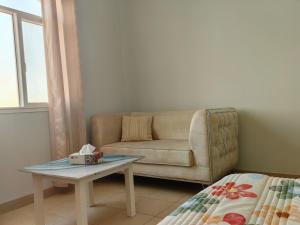 a living room with a couch and a table at Bloom Flat in Muscat