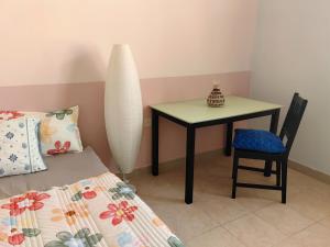 a bedroom with a table and a chair next to a bed at Bloom Flat in Muscat