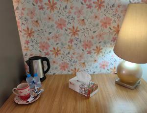 a table with a lamp and a box on it at Bloom Flat in Muscat