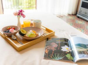 a tray with a plate of food and a book at Phutaya Wellness Retreat in Phra Nakhon Si Ayutthaya