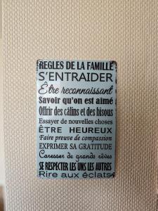 a sign on the side of a white wall with at Appartement agréable et atypique, rénové, wifi, terrasse, jardin in Schleithal