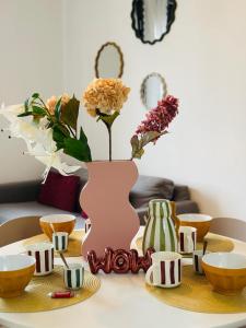 a table with a pink vase with flowers in it at Le Cherry - Plein centre Rheu in Le Rheu