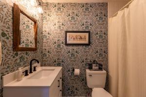 a bathroom with a toilet and a sink and a mirror at Elk Watch at Hound Ears in Valle Crucis +30 photos