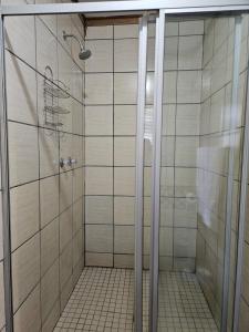 ein Bad mit einer Dusche und weißen Fliesen in der Unterkunft 15 Elizabeth Eybers str in Bloemfontein