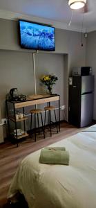 Schlafzimmer mit einem Schreibtisch und einem TV an der Wand in der Unterkunft 15 Elizabeth Eybers str in Bloemfontein