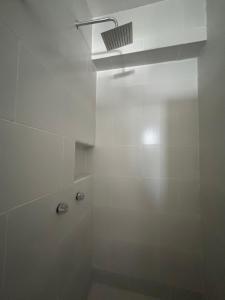 a white bathroom with a shower with a ceiling at loft in Hermosillo