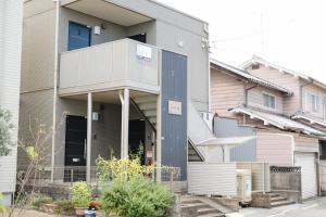 a house with a blue door on a street at ハイツNagomi in Otsu