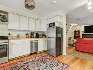 Una cocina con gabinetes blancos y un refrigerador de acero inoxidable. en Courtyard Off Madison Square, en Savannah