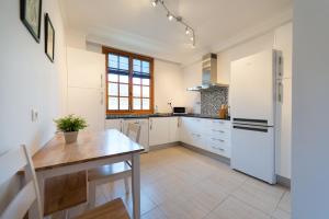 a kitchen with a table and a white refrigerator at Malfu Home in Las Palmas de Gran Canaria