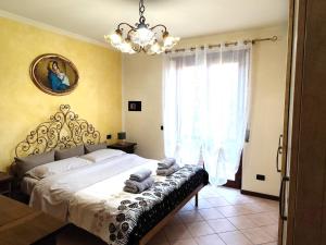 1 dormitorio con 1 cama con lámpara de araña y ventana en Balconi sul Verde, en Pescantina