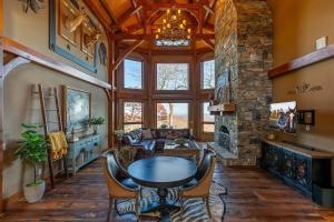 a living room with a table and a stone fireplace at Bailey's Creek Lodge in Blowing Rock