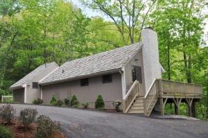 a white house with a porch and a deck at White Oak Cabin in Banner Elk