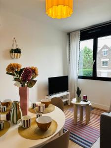 a living room with a table and chairs at Le Cherry - Plein centre Rheu in Le Rheu