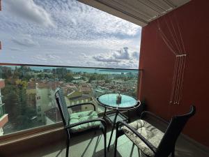 a balcony with a table and chairs and a large window at Breathtaking sea view apartment in Varna City
