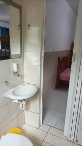 a bathroom with a sink and a mirror at Kintal da Ka in São Sebastião