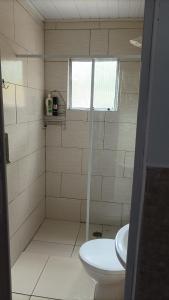 a bathroom with a shower with a toilet and a sink at Kintal da Ka in São Sebastião
