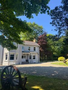 a large white house with a cannon in front of it at Luxury Escape with Hot Tub in County Antrim in Kells