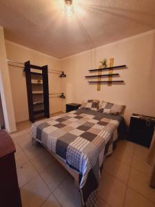 une chambre avec un lit avec une couverture à carreaux dans l'établissement Casa La Choca, à Tierra Colorada
