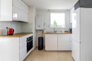 a white kitchen with white cabinets and a window at Cosy T4 proche hyper centre in Vannes