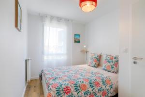 a bedroom with a bed with a colorful bedspread at Cosy T4 proche hyper centre in Vannes