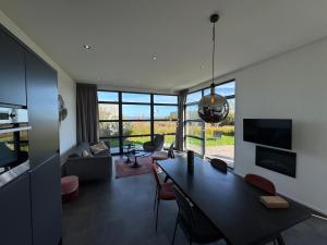 a living room with a table and a living room with a view at Enkhuizer Strand Chalet Leuke Plek Haus Nr 216 in Enkhuizen