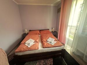 a bedroom with a bed with orange sheets and a window at Wypoczynek Między Świerkami in Ustroń