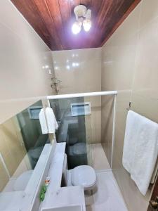 a bathroom with a white toilet and a sink at Pousada Shalom Beach in Maragogi