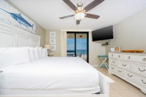 een slaapkamer met een wit bed en een plafondventilator bij Phoenix VI 6708 condo in Orange Beach