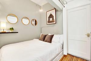 a bedroom with a white bed and mirrors on the wall at Downtown at the Derenne in Savannah +29 photos
