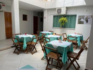 a group of tables with green table cloths in a restaurant at Pousada Sagrada Devoção in Aparecida
